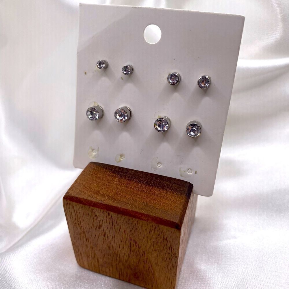 Set of 4 pairs of silver toned magnetic stud rhinestone earrings.